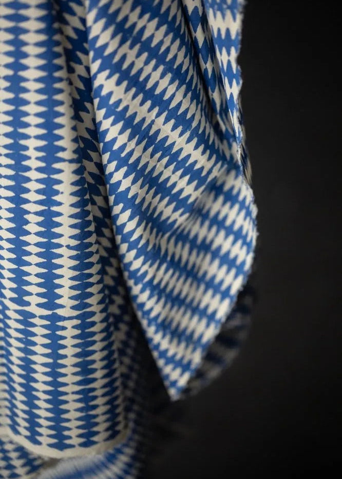 Close-up of blue and white checkered fabric against a black background