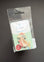 A Peter Rabbit Needle Pin set in its original clear plastic blister packaging, displayed against a dark gray background.