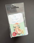 A Peter Rabbit Needle Pin set in its original clear plastic blister packaging, displayed against a dark gray background.